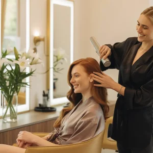 Estilista profesional peinando a una clienta en un salón moderno y luminoso